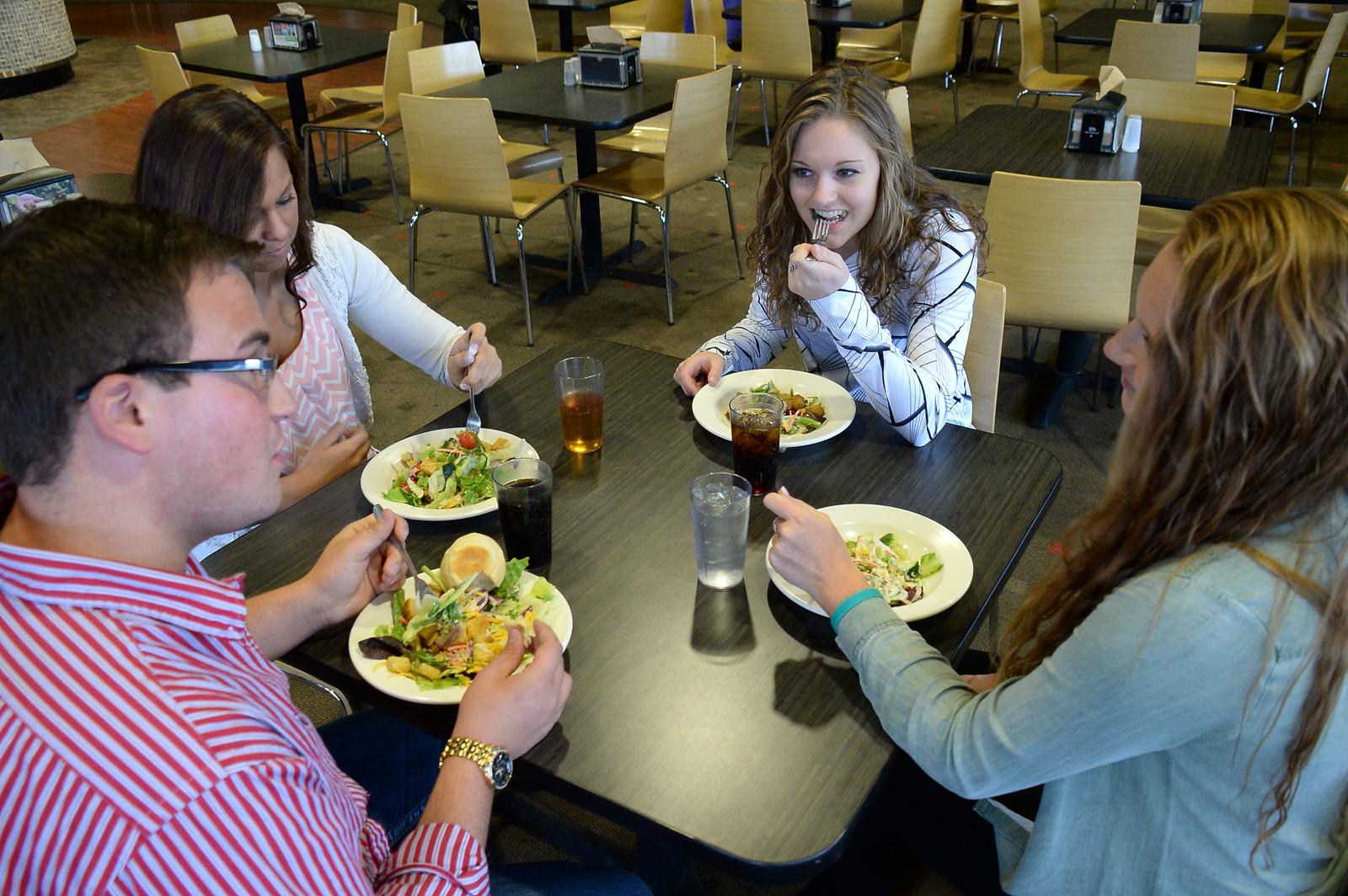 四个学生坐在一起吃沙拉
