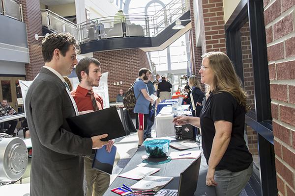 Two students interviewing a potential employer at a job fair in the Technology Center