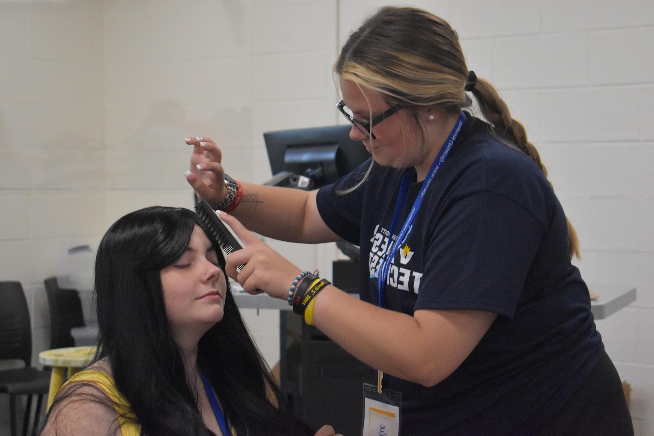 美容专业的学生正在给一位女士做发型