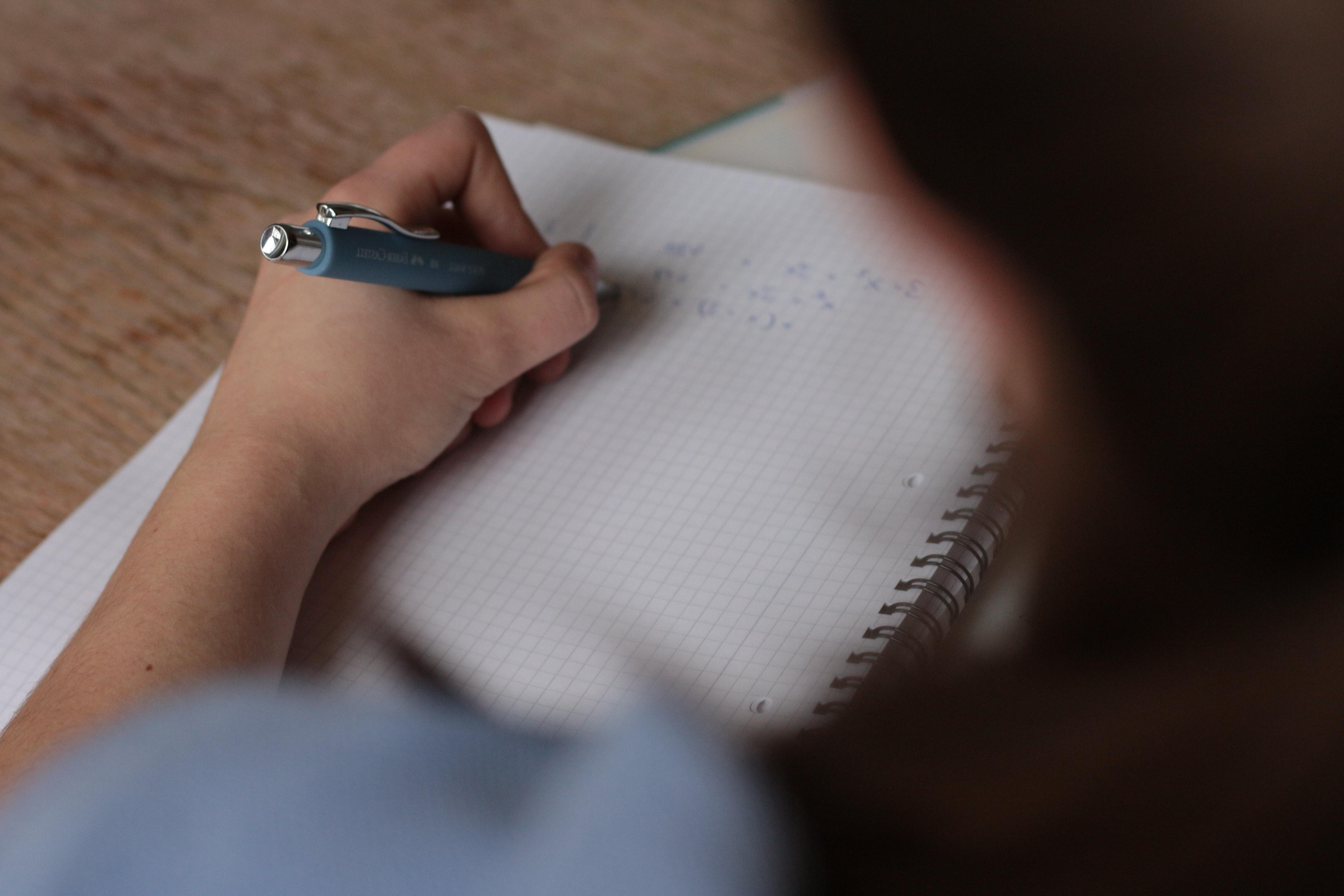 A student using a pen on graph paper