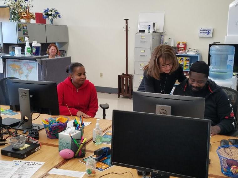 Tricia Trent helping two students in a lab